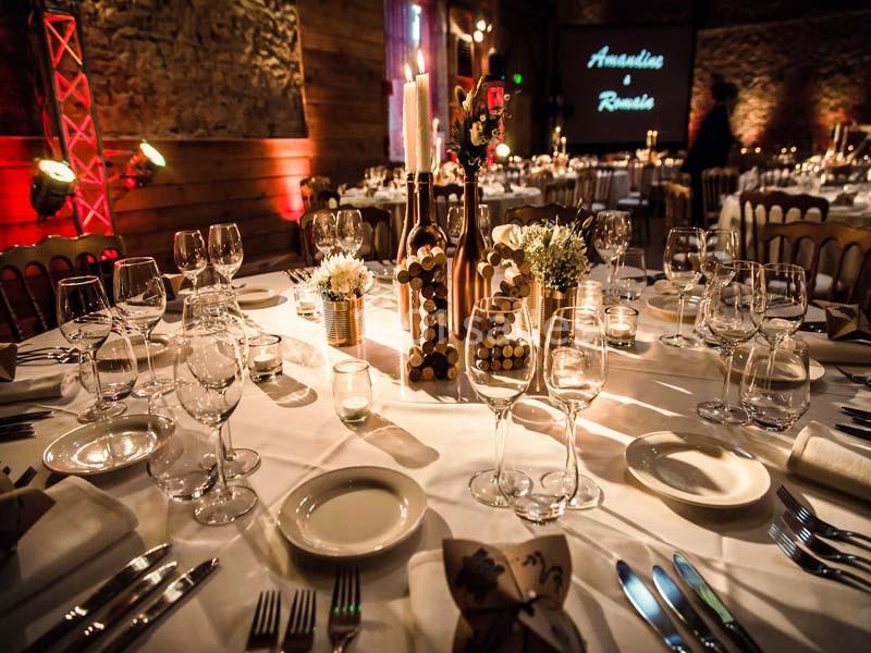Table élégamment dressée pour un événement, avec bougies, fleurs et décorations en liège dans une ambiance tamisée.
