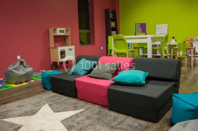 Miniature Location salle Villeparisis (Seine-et-Marne) - Espace Eden #39 Salle de jeux lumineuse avec une cabane en tissu, un tapis de chiffres, une cuisine pour enfants et des tables colorées.