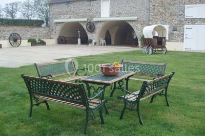 Salle de réception en pierre décorée de ballons rouges et blancs, avec tables dressées pour un événement.