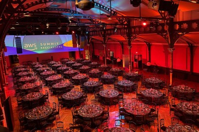 Salle intérieure avec mezzanine, escaliers symétriques, balustrades en métal décoratif et parquet au sol.