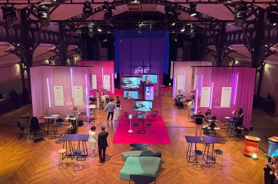 Salle intérieure avec mezzanine, escaliers symétriques, balustrades en métal décoratif et parquet au sol.