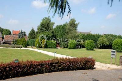 Miniature Location salle Pont-à-Celles (Hainaut) - La Ferme de la Pitance #3 Salle de réception avec tables dressées, nappes beiges, chandeliers et poutres apparentes sous un toit vitré.