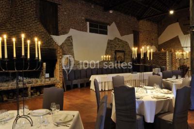 Miniature Location salle Pont-à-Celles (Hainaut) - La Ferme de la Pitance #4 Salle de réception avec tables dressées, nappes beiges, chandeliers et poutres apparentes sous un toit vitré.