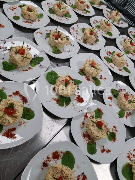 Assiettes dressées avec des portions de salade composée sur lit de jeunes pousses, décorées de tomates cerises et herbes.