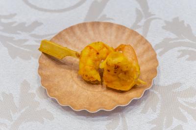 Salle de réception décorée avec une table dressée, un centre de table floral et une arche fleurie en arrière-plan.