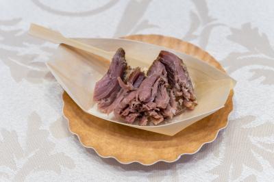 Salle de réception décorée avec une table dressée, un centre de table floral et une arche fleurie en arrière-plan.