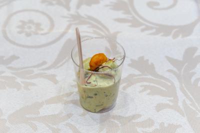 Salle de réception décorée avec une table dressée, un centre de table floral et une arche fleurie en arrière-plan.