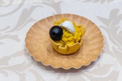 Salle de réception décorée avec une table dressée, un centre de table floral et une arche fleurie en arrière-plan.