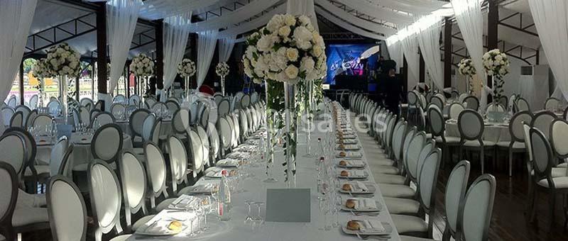 Location salle Rueil-Malmaison (Hauts-de-Seine) - Paris Country Club #27 Salle de réception décorée avec des tables alignées, nappes blanches, chaises élégantes et arrangements floraux.