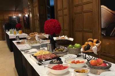 Miniature Location salle Rueil-Malmaison (Hauts-de-Seine) - Paris Country Club #16 Chambre d'hôtel lumineuse avec lit double, bureau bleu, fauteuil, télévision et balcon offrant une vue sur l'extérieur.