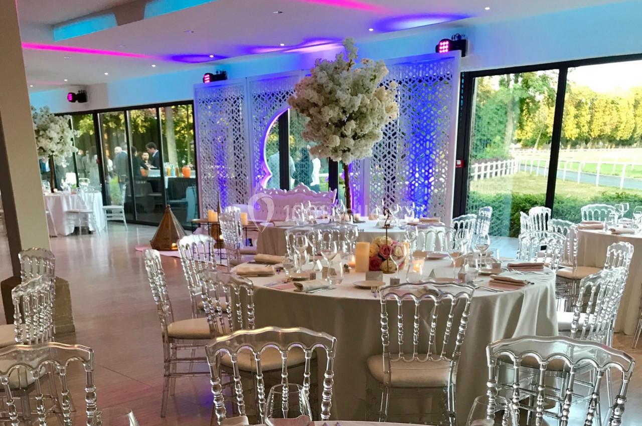 Location salle Rueil-Malmaison (Hauts-de-Seine) - Paris Country Club #5 Salle de réception décorée avec des tables élégantes, des chaises transparentes et des arrangements floraux blancs.