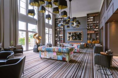 Miniature Location salle Rueil-Malmaison (Hauts-de-Seine) - Paris Country Club #8 Chambre d'hôtel lumineuse avec lit double, bureau bleu, fauteuil, télévision et balcon offrant une vue sur l'extérieur.