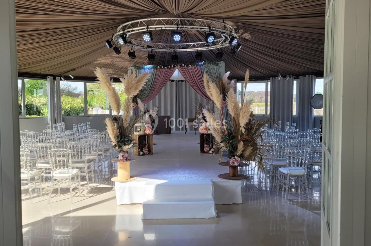 Location salle Rueil-Malmaison (Hauts-de-Seine) - Paris Country Club #23 Salle de réception décorée avec des chaises transparentes, des arrangements floraux et un éclairage suspendu.