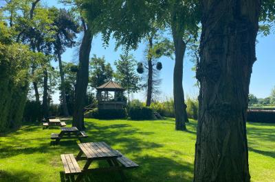 Miniature Location salle Rueil-Malmaison (Hauts-de-Seine) - Paris Country Club #4 Chambre d'hôtel lumineuse avec lit double, bureau bleu, fauteuil, télévision et balcon offrant une vue sur l'extérieur.