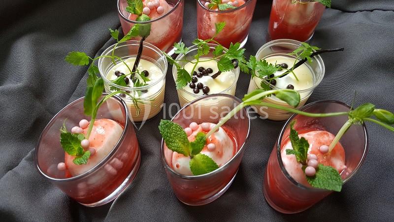 Verrines de desserts variés avec mousse, fruits rouges, perles décoratives et feuilles de menthe sur tissu gris.