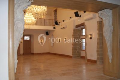 Allée éclairée par des lampes au sol, bordée d'arbres et menant à une entrée illuminée dans l'obscurité.