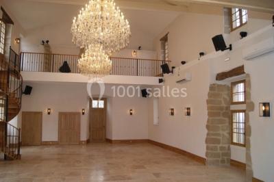 Allée éclairée par des lampes au sol, bordée d'arbres et menant à une entrée illuminée dans l'obscurité.