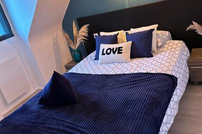 Miniature Location salle Rostrenen (Côtes-d'Armor) - Domaine Un Jour Parfait #21 Chambre moderne avec mur vert, lit double décoré de coussins, luminaires muraux et tapis clair au sol.