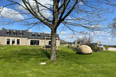 Miniature Location salle Rostrenen (Côtes-d'Armor) - Domaine Un Jour Parfait #5 Chambre moderne avec mur vert, lit double décoré de coussins, luminaires muraux et tapis clair au sol.