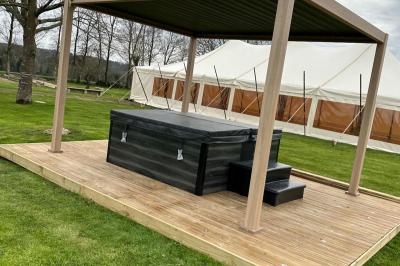 Miniature Location salle Rostrenen (Côtes-d'Armor) - Domaine Un Jour Parfait #13 Chambre moderne avec mur vert, lit double décoré de coussins, luminaires muraux et tapis clair au sol.