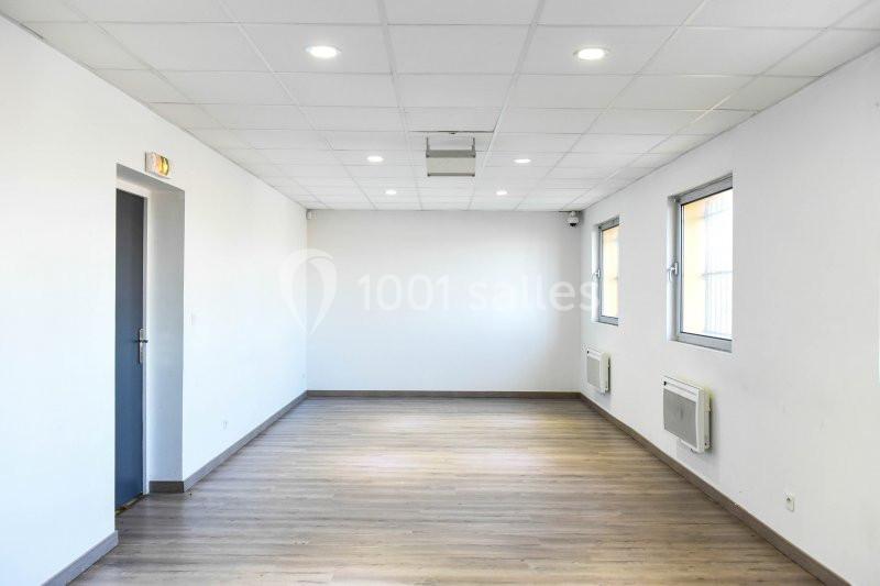 Location salle Hénin-Beaumont (Pas-de-Calais) - Team Square Events #11 Salle vide avec parquet en bois, murs blancs, plafond à dalles et éclairage encastré, deux fenêtres et une porte.