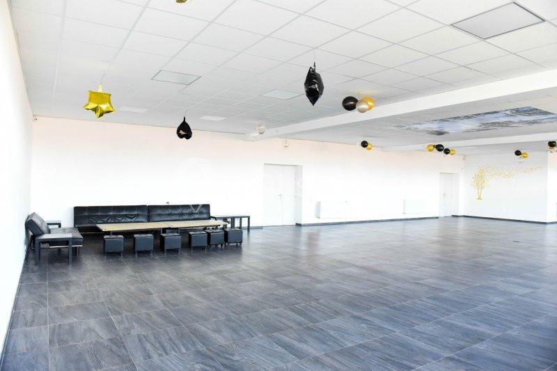 Location salle Hénin-Beaumont (Pas-de-Calais) - Team Square Events #3 Salle spacieuse avec sol en carrelage gris, plafond blanc et quelques décorations suspendues.