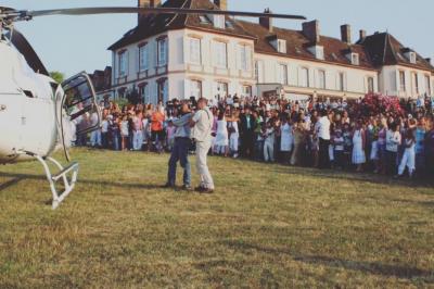 Parking extérieur avec plusieurs voitures stationnées, entouré d'arbres et offrant une vue dégagée au loin.