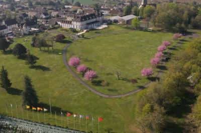 Parking extérieur avec plusieurs voitures stationnées, entouré d'arbres et offrant une vue dégagée au loin.