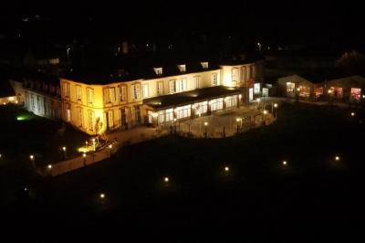 Parking extérieur avec plusieurs voitures stationnées, entouré d'arbres et offrant une vue dégagée au loin.
