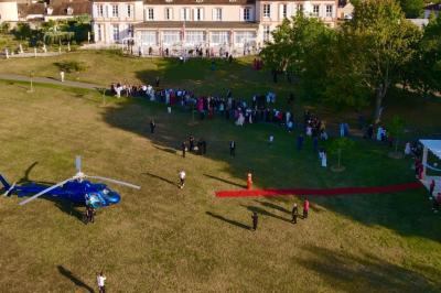 Parking extérieur avec plusieurs voitures stationnées, entouré d'arbres et offrant une vue dégagée au loin.