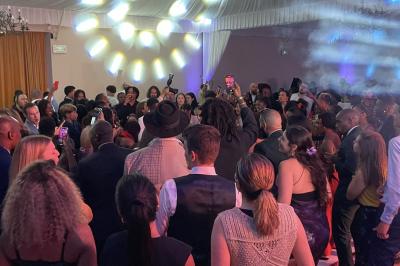 Parking extérieur avec plusieurs voitures stationnées, entouré d'arbres et offrant une vue dégagée au loin.