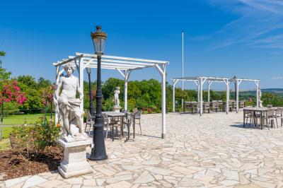 Parking extérieur avec plusieurs voitures stationnées, entouré d'arbres et offrant une vue dégagée au loin.