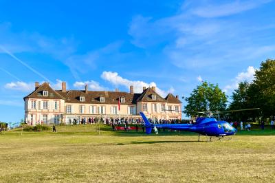 Parking extérieur avec plusieurs voitures stationnées, entouré d'arbres et offrant une vue dégagée au loin.
