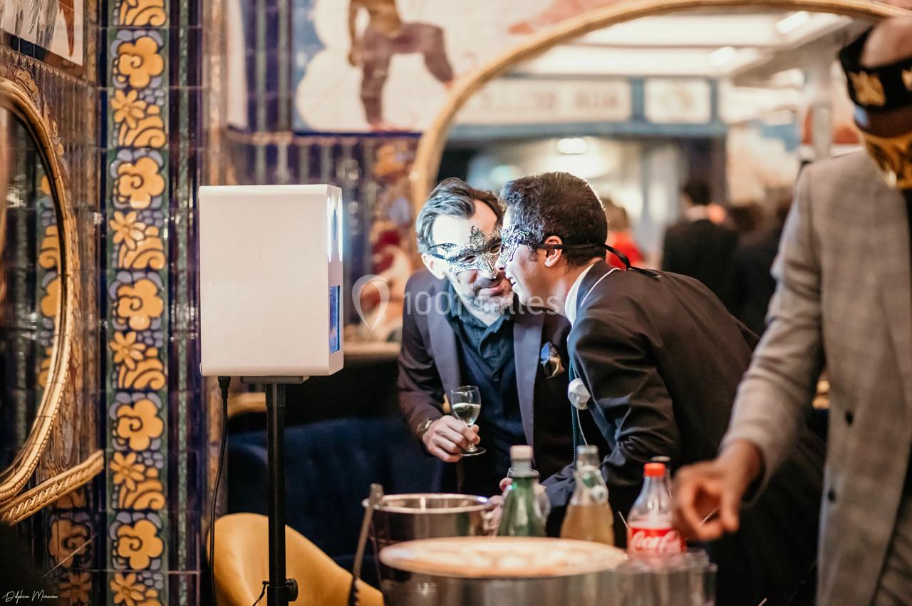 Location salle Paris 2 (Paris) - Aux Belles Poules #11 Deux hommes discutent près d'une table avec des boissons, dans un espace décoré de miroirs et de carreaux colorés.