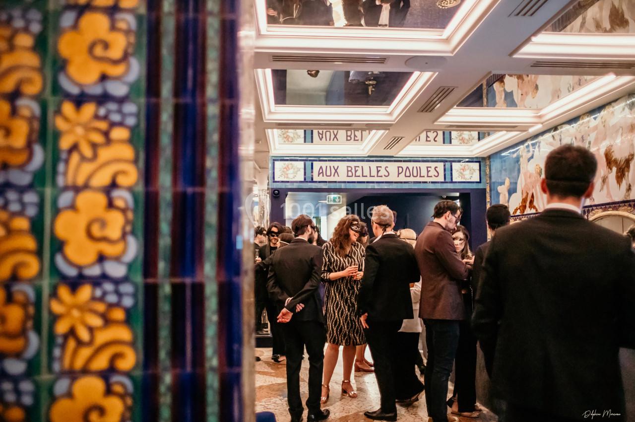 Location salle Paris 2 (Paris) - Aux Belles Poules #15 Groupe de personnes en tenue élégante discutant dans un intérieur décoré de carreaux colorés et miroirs.