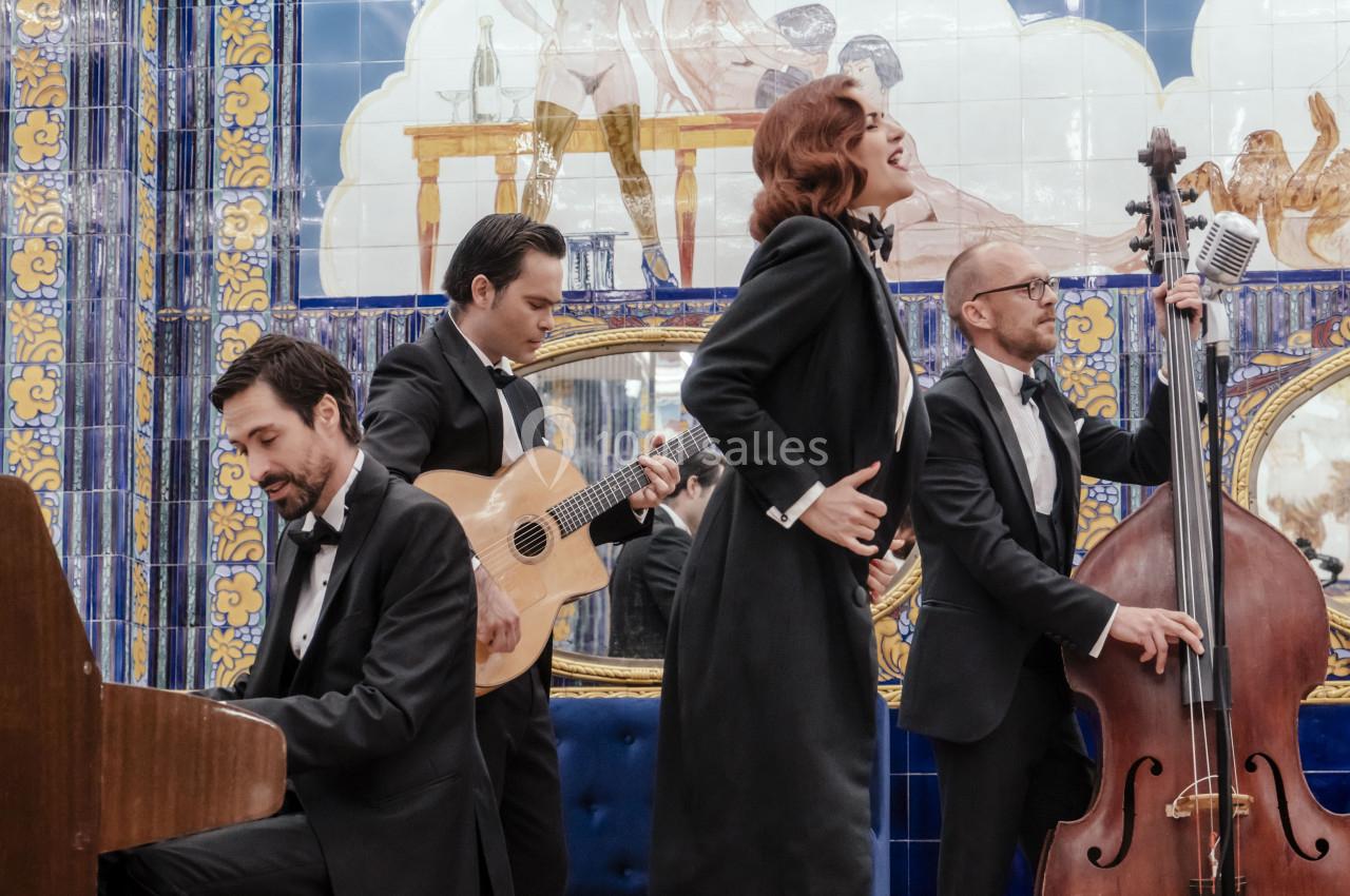 Location salle Paris 2 (Paris) - Aux Belles Poules #18 Un groupe en tenue élégante joue de la musique dans une salle décorée de carreaux colorés et de miroirs.
