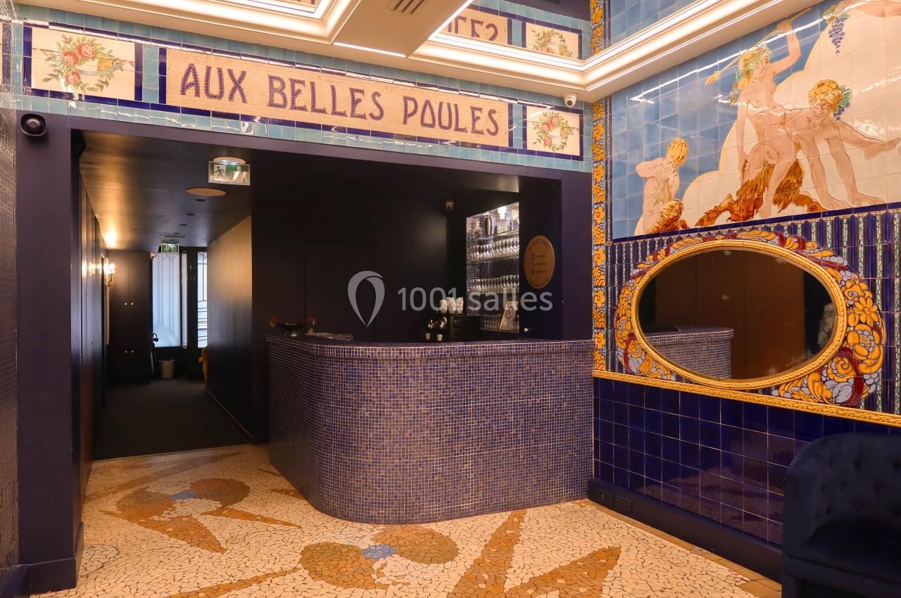 Location salle Paris 2 (Paris) - Aux Belles Poules #5 Accueil d'un établissement décoré de mosaïques bleues et de fresques murales, avec un comptoir arrondi en carrelage.