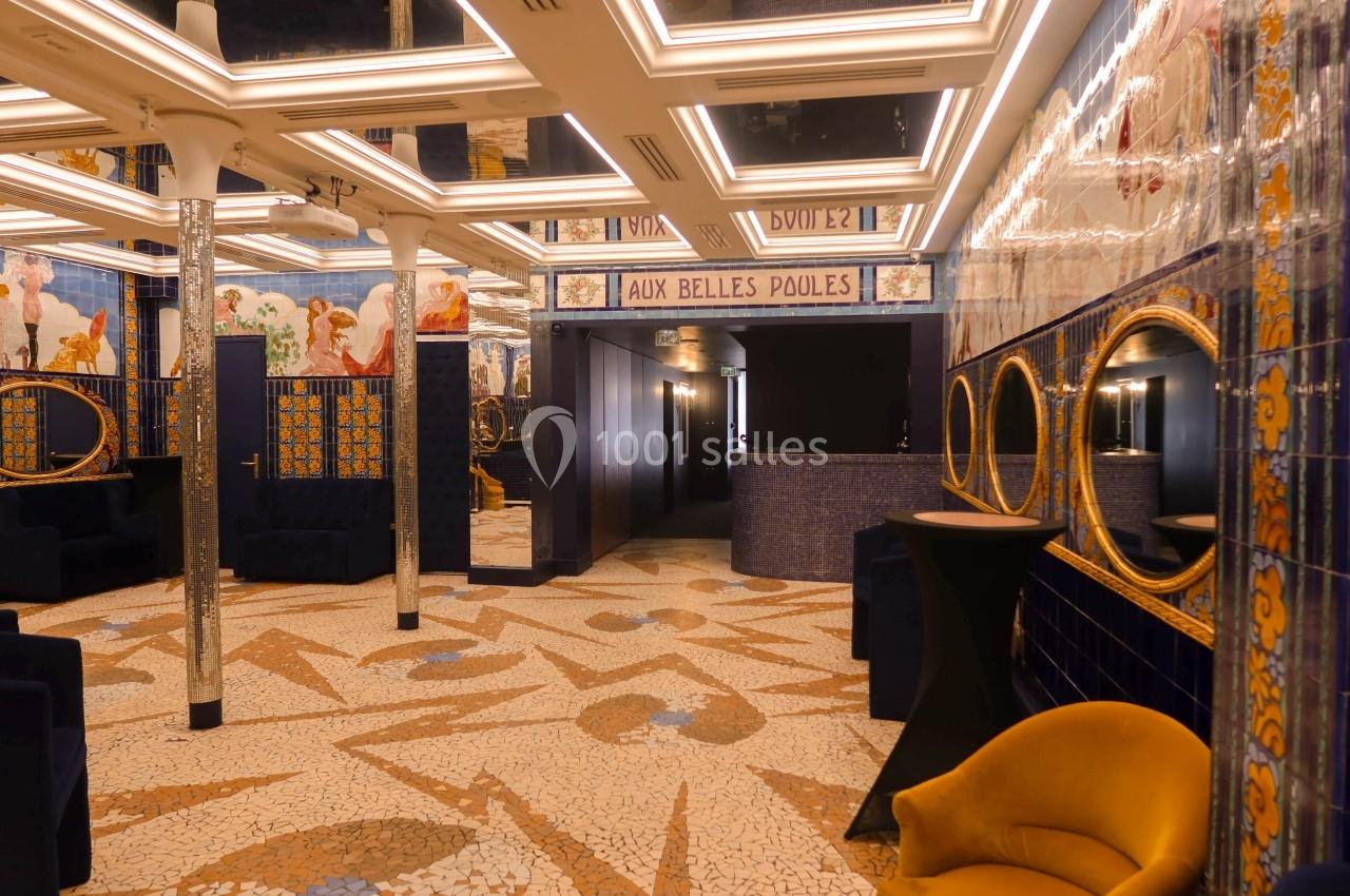 Location salle Paris 2 (Paris) - Aux Belles Poules #2 Salle décorée de mosaïques au sol, murs ornés de fresques et miroirs, avec fauteuils et éclairage lumineux.