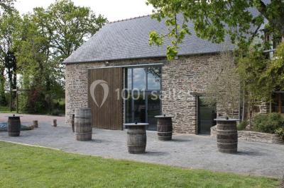 Miniature Location salle Plélan-le-Grand (Ille-et-Vilaine) - Domaine Le 5b #7 Table ronde décorée pour un repas, avec nappes blanches, couverts disposés, fleurs et éléments naturels en centre de table.