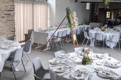 Miniature Location salle Plélan-le-Grand (Ille-et-Vilaine) - Domaine Le 5b #15 Table ronde décorée pour un repas, avec nappes blanches, couverts disposés, fleurs et éléments naturels en centre de table.