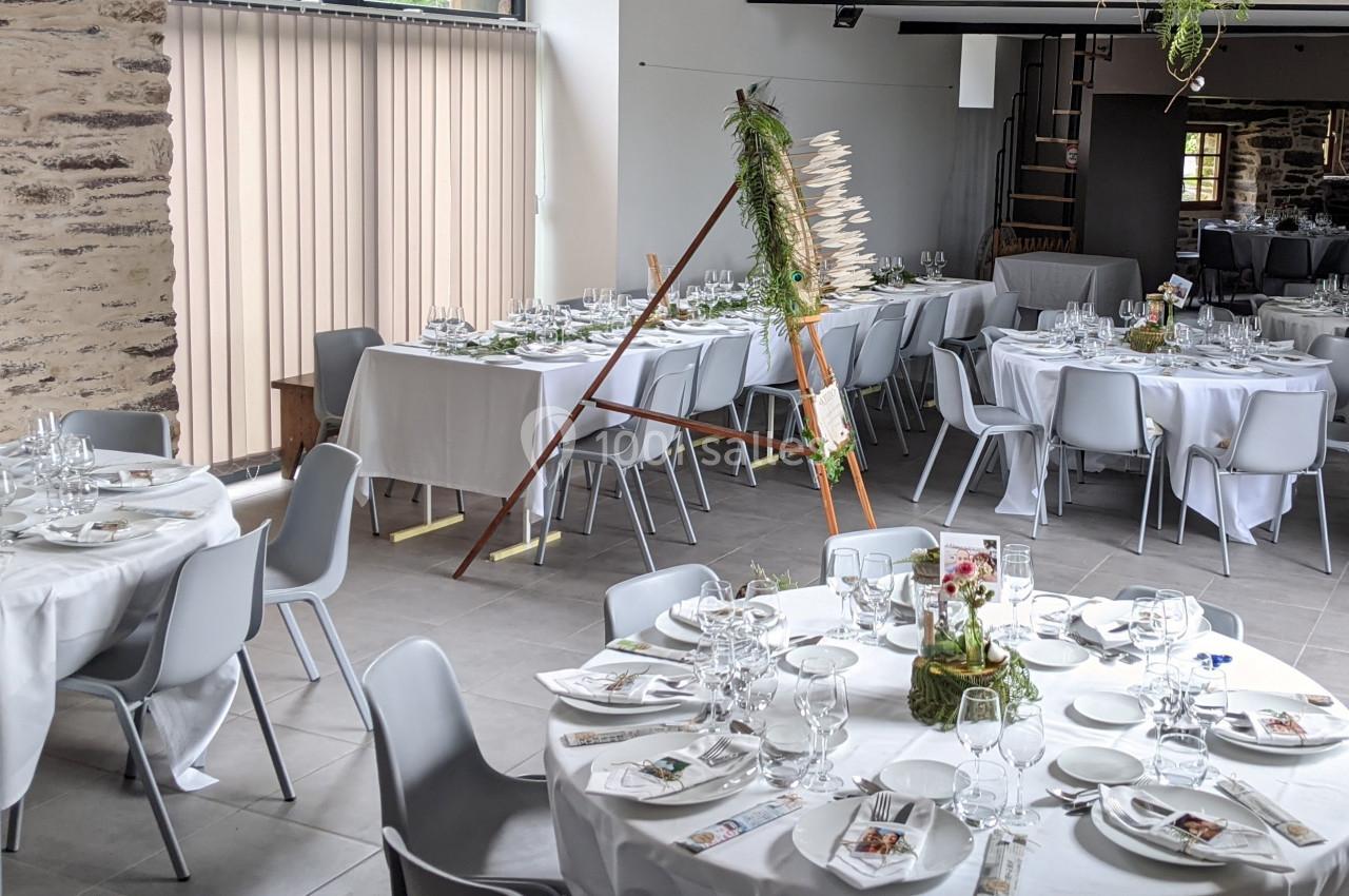 Location salle Plélan-le-Grand (Ille-et-Vilaine) - Domaine Le 5b #15 Salle de réception décorée avec des tables rondes dressées, nappes blanches et éléments floraux.