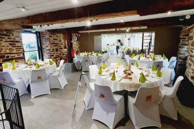 Miniature Location salle Plélan-le-Grand (Ille-et-Vilaine) - Domaine Le 5b #14 Table ronde décorée pour un repas, avec nappes blanches, couverts disposés, fleurs et éléments naturels en centre de table.