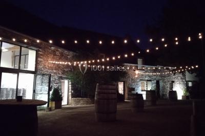 Miniature Location salle Plélan-le-Grand (Ille-et-Vilaine) - Domaine Le 5b #34 Table ronde décorée pour un repas, avec nappes blanches, couverts disposés, fleurs et éléments naturels en centre de table.