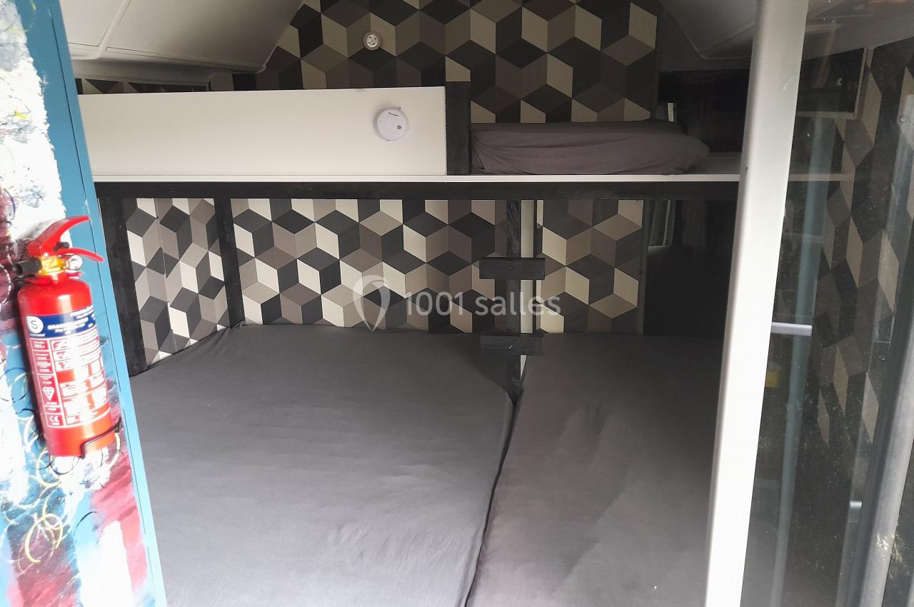 Location salle Plélan-le-Grand (Ille-et-Vilaine) - Domaine Le 5b #39 Lits superposés avec matelas gris dans un espace compact, décoré de motifs géométriques sur les murs.