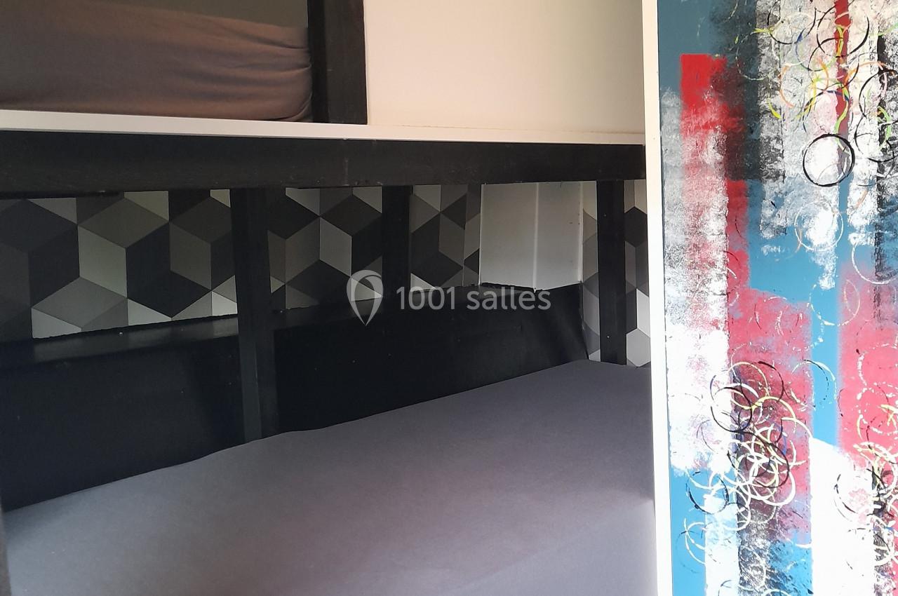Location salle Plélan-le-Grand (Ille-et-Vilaine) - Domaine Le 5b #41 L'intérieur d'un véhicule aménagé avec deux lits superposés et une porte décorée de motifs colorés.