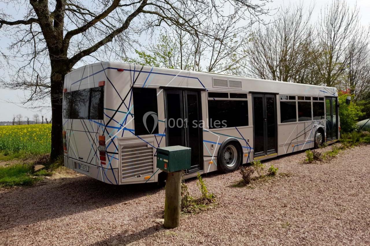 Location salle Plélan-le-Grand (Ille-et-Vilaine) - Domaine Le 5b #37 Autobus stationné sur un chemin gravillonné, entouré d'arbres et de champs sous un ciel clair.