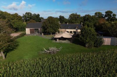 Miniature Location salle Plélan-le-Grand (Ille-et-Vilaine) - Domaine Le 5b #1 Table ronde décorée pour un repas, avec nappes blanches, couverts disposés, fleurs et éléments naturels en centre de table.
