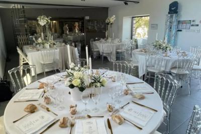 Miniature Location salle Plélan-le-Grand (Ille-et-Vilaine) - Domaine Le 5b #52 Table ronde décorée pour un repas, avec nappes blanches, couverts disposés, fleurs et éléments naturels en centre de table.