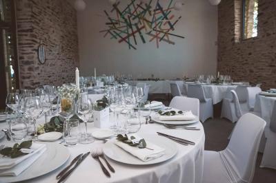 Miniature Location salle Plélan-le-Grand (Ille-et-Vilaine) - Domaine Le 5b #53 Table ronde décorée pour un repas, avec nappes blanches, couverts disposés, fleurs et éléments naturels en centre de table.