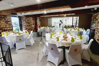 Miniature Location salle Plélan-le-Grand (Ille-et-Vilaine) - Domaine Le 5b #55 Table ronde décorée pour un repas, avec nappes blanches, couverts disposés, fleurs et éléments naturels en centre de table.